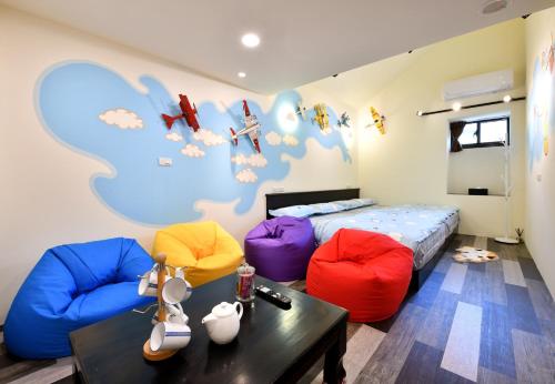 a bedroom with two beds and a table and chairs at Windsor's Vanilla Garden B&B in Jiufen