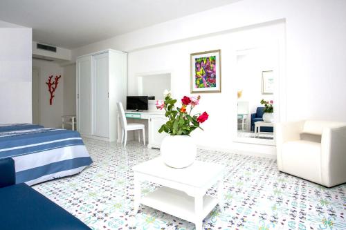 a bedroom with a bed and a table with flowers on it at Hotel Ferretti in Diamante