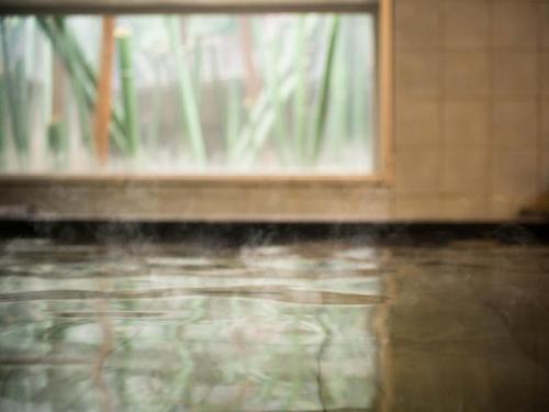 a window in a room with water on the floor at Super Hotel Nagaizumi Numazu Inter in Nagaizumi