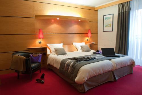 เตียงในห้องที่ Hotel & Résidence Les Vallées Labellemontagne