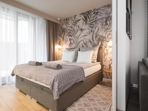 a bedroom with a bed with a tropical wallpaper at Jacuzzi Apartments in Kraków