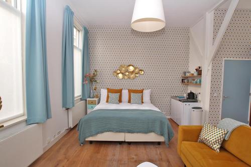 a bedroom with a bed and a couch at Citystays Deventer in Deventer