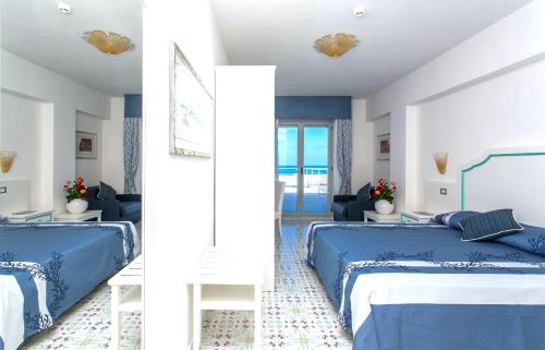 a bedroom with two beds and a living room at Hotel Ferretti in Diamante