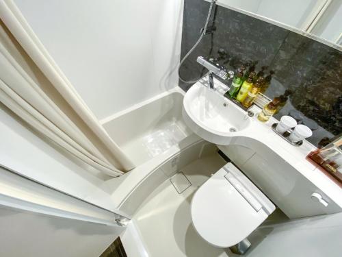 małą łazienkę z toaletą i umywalką w obiekcie HOTEL LiVEMAX Okayama Kurashiki Ekimae w mieście Kurashiki
