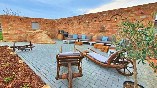 a patio with furniture and a brick wall at Penzion jako víno in Bulhary