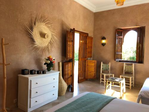 a bedroom with a bed and a dresser and a window at Domaine Casa Cecilia in Marrakech
