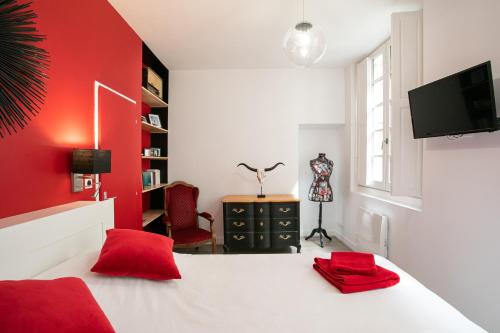 Dormitorio rojo con cama blanca y pared roja en Corps et graphi(qu)es en Périgueux