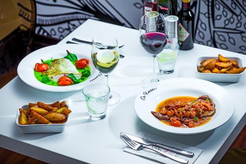 a table with plates of food and glasses of wine at George Limerick Hotel in Limerick