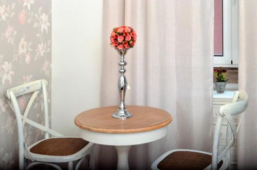 リスボンにあるSweet Suites Guesthouse close to famous Avenue Libertyの花瓶のテーブルと椅子2脚
