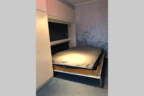 een kleine slaapkamer met een bed in een kamer bij Ruim 3 slaapkamerappartement vlakbij het strand in Koksijde