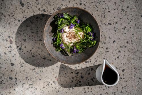 a bowl of food on a table with a bowl of salad at Grønbechs Hotel in Allinge
