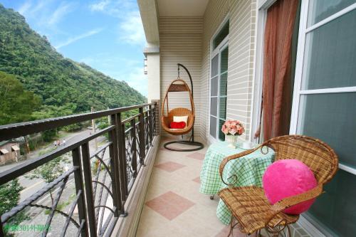 ein Balkon mit Stühlen und einem Tisch und einer Aussicht in der Unterkunft Forest Love in Datong