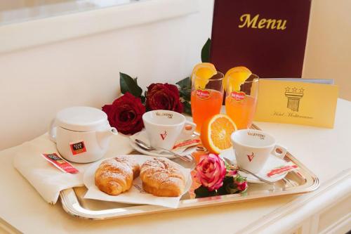 een dienblad met gebak, koffie en bloemen op een tafel bij Hotel Mediterraneo in Porto Cesareo