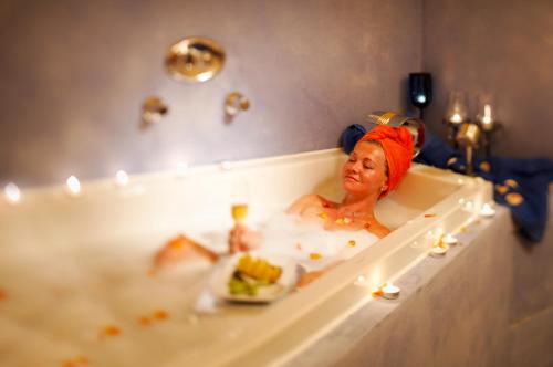 een vrouw in een bad met een bord eten bij Hotel Berghof in Pfronten