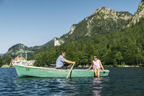 a man and a girl in a boat on the water at Hotel Berghof in Pfronten