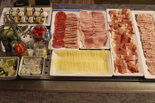 a tray with different types of meats and other foods at Hotel Berghof in Pfronten