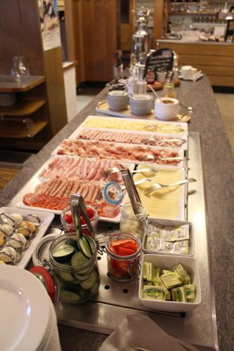 a buffet line with different types of meats and food at Hotel Berghof in Pfronten