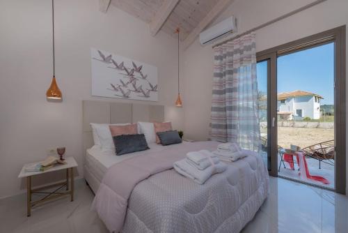a bedroom with a large bed with towels on it at Zante Prime Villas in Gaïtánion