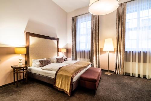 una camera d'albergo con un letto e due finestre di Aparthotel Am Schloss a Dresda