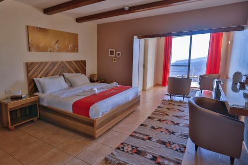 sypialnia z dużym łóżkiem i dużym oknem w obiekcie Dana Guesthouse w mieście Dana