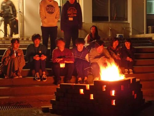 a group of people sitting around a fire at YUKUSA OHSUMI UMI no GAKKO in Kanoya
