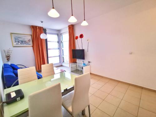 a dining room with a green table and chairs at Migdal Palace in Eilat