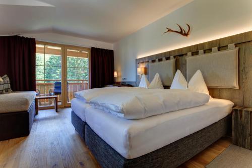 a hotel room with a large bed and a balcony at Kösslerhof in Sankt Anton am Arlberg