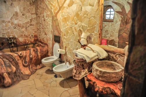 baño con una decoración inspirada en los árboles, aseo y lavabo en Club Vila Bran, en Bran