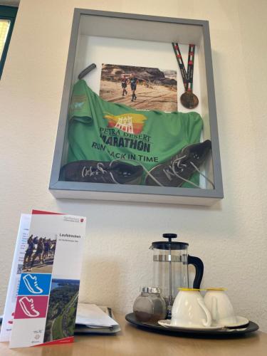 a picture hanging on a wall above a table with a blender at Hotel-Pension Mandy - Adults Only in Senftenberg