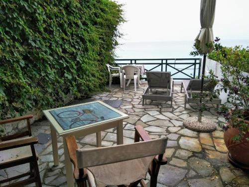 a patio with chairs and a table with a view of the ocean at Armenistis View Studios in Armenistis