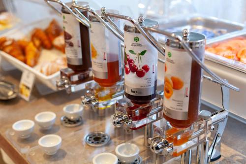a row of wine bottles on a counter with food at Hotel Mirage Sure Hotel Collection by Best Western in Milan