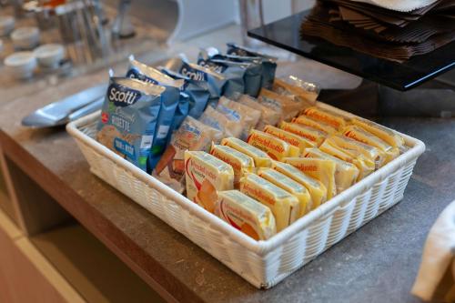 a counter with a basket of cheese and other food at Hotel Mirage Sure Hotel Collection by Best Western in Milan