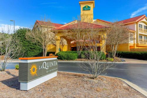 La Quinta by Wyndham Raleigh Durham Intl AP في موريسفيل: مبنى اصفر عليه برج الساعه