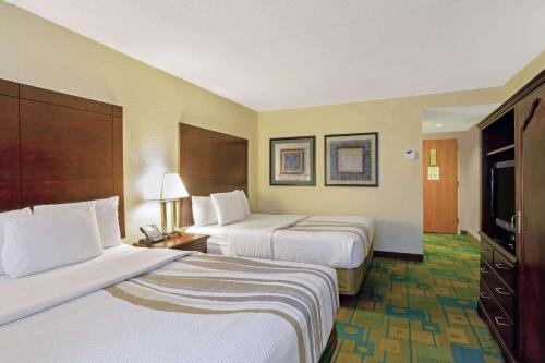 a hotel room with two beds and a television at La Quinta by Wyndham Boston Somerville in Somerville