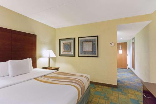 a hotel room with a large bed and a hallway at La Quinta by Wyndham Boston Somerville in Somerville