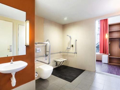 a bathroom with a toilet and a sink and a shower at Ibis Singapore Novena in Singapore