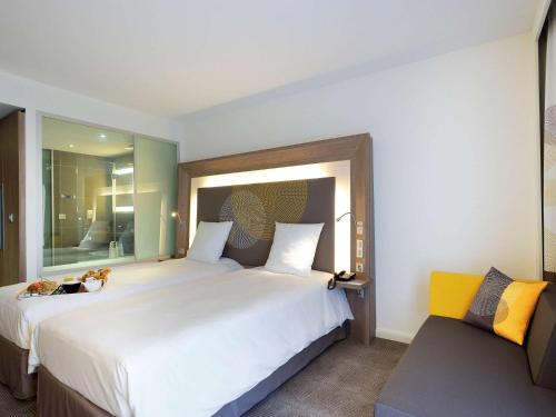 a bedroom with a large bed and a large window at Novotel Avignon Centre in Avignon