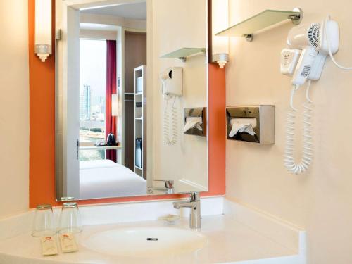 a bathroom with a sink and a mirror at Ibis Hong Kong Central & Sheung Wan in Hong Kong