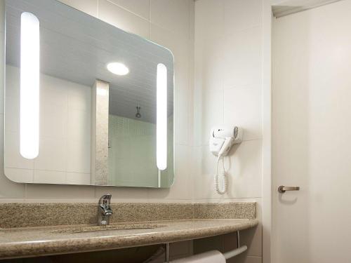 a bathroom with a sink and a mirror at ibis Mogi das Cruzes Shopping in Mogi das Cruzes