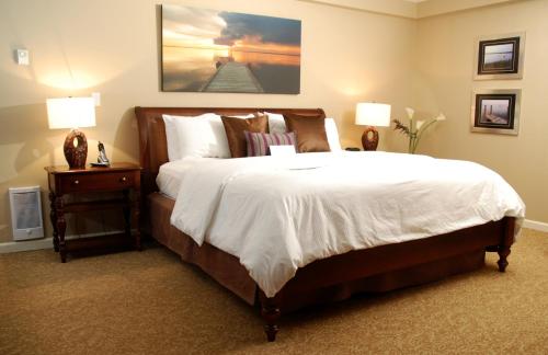 a bedroom with a large bed and two lamps at Rosellen Suites at Stanley Park in Vancouver