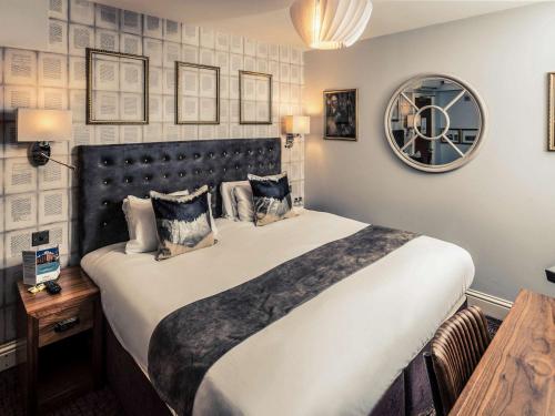 a bedroom with a large bed and a mirror at Mercure Nottingham City Centre Hotel in Nottingham