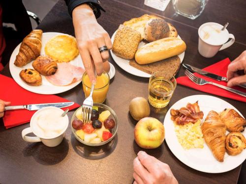 a table with plates of breakfast food on it at ibis Leiden Centre in Leiden