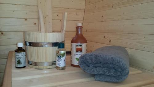 a wooden shelf with two bottles and a towel at Hochleiten-Gut in Niedernsill