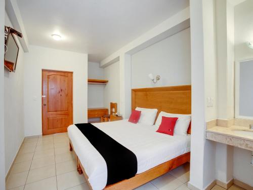 a bedroom with a large bed with red pillows at Hotel Patzcuaro in Pátzcuaro