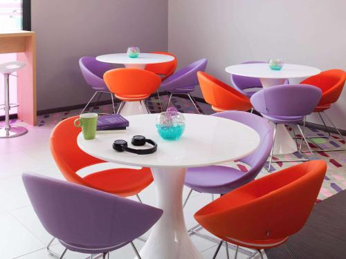 a group of tables and chairs in a room at ibis Styles Montbéliard in Montbéliard