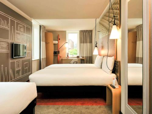 Habitación de hotel con 2 camas y TV en ibis Rotterdam City Centre en Róterdam