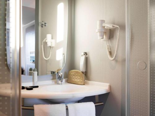 een badkamer met een wastafel en een spiegel bij ibis Rotterdam City Centre in Rotterdam