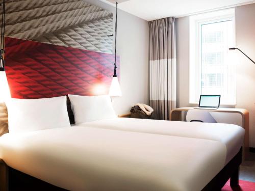 
a hotel room with a white bed and white walls at ibis Rotterdam City Centre in Rotterdam
