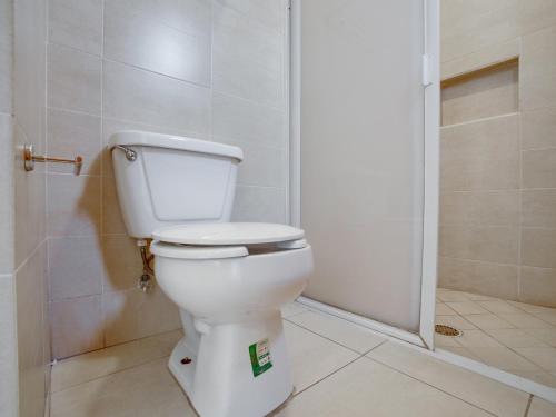 a white toilet in a bathroom with a shower at Hotel Patzcuaro in Pátzcuaro