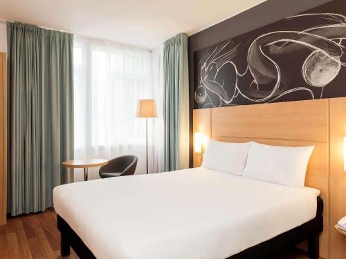 a hotel room with a large bed and a large window at ibis Edinburgh Centre South Bridge – Royal Mile in Edinburgh